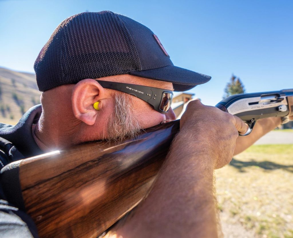 Man aiming a rifle outside and wearing speed demon glasses